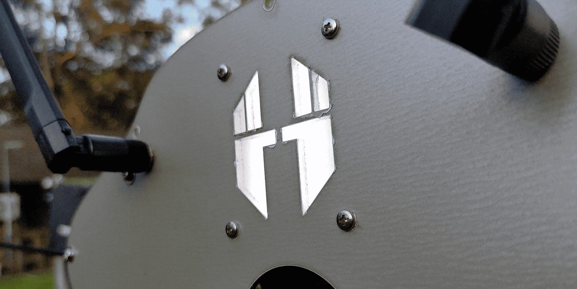Close-up of the camera car's grey housing, showing the Fliight logo cut into the panel beside an antenna and lens