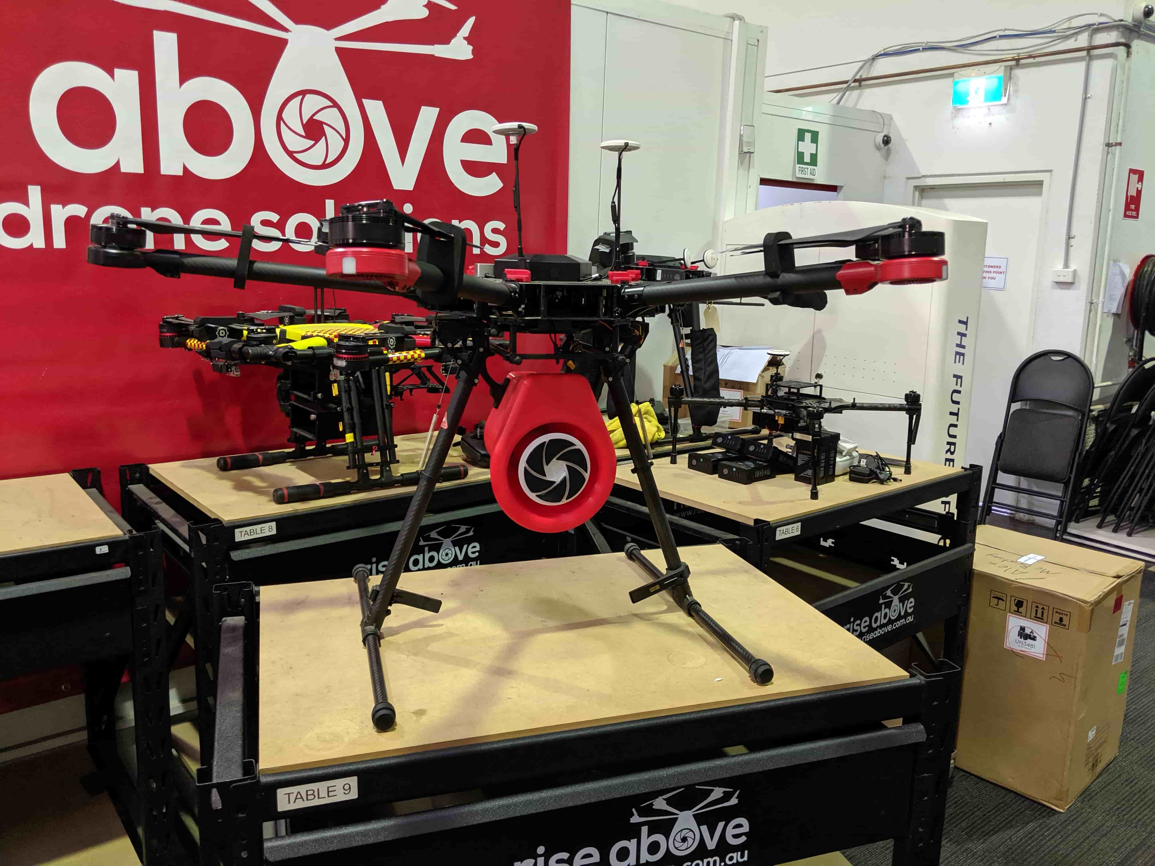 Complete megaphone-equipped drone in the workshop alongside other UAV platforms