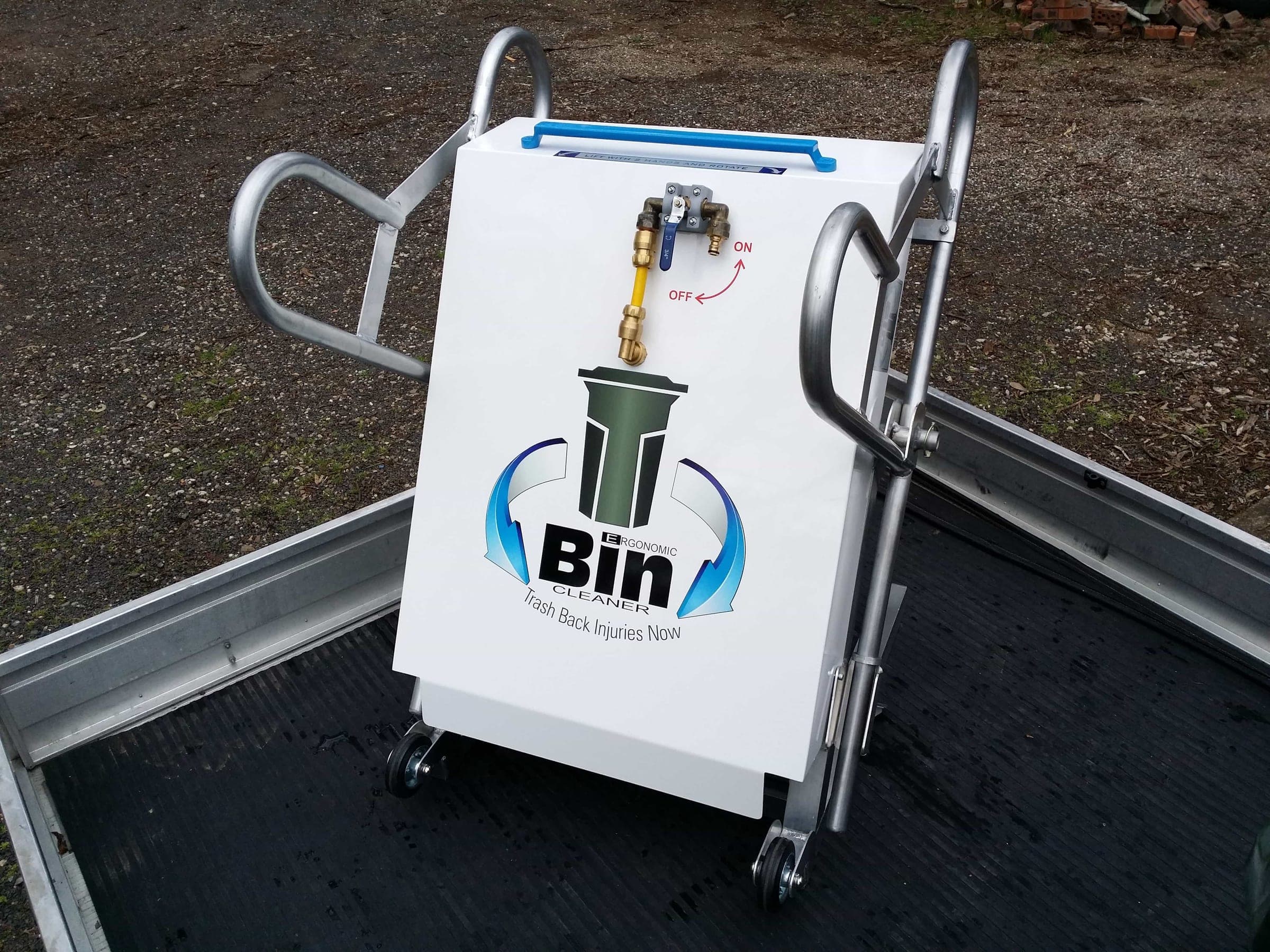 Finished T-Bin cleaning station installed in a trailer with a wheelie bin held in the rotating wash mechanism